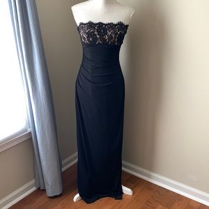 Strapless black dress with lace bust accent, side ruching, and sexy side slit.